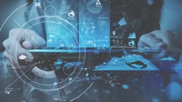 Person using laptop with digital interface overlay displaying graphs and network icons.