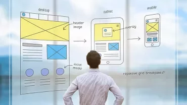 Person observing web design sketches on glass screen.