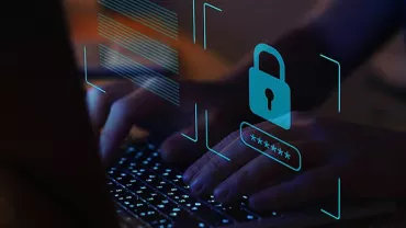 Hands typing on a laptop keyboard with a digital security padlock icon.