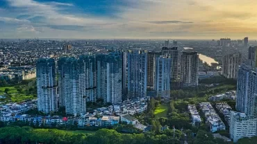 Aerial view of a cityscape with tall buildings and a river under a clear sky.