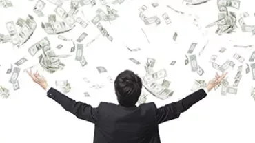 Person in suit with arms raised, surrounded by falling dollar bills.