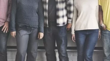 Group of people standing side by side in casual clothing.