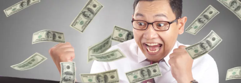 Excited person with glasses surrounded by falling dollar bills.