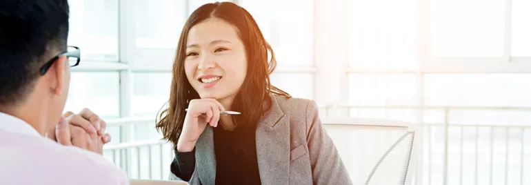 Two people having a conversation in a bright office setting.
