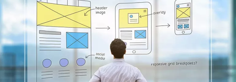 Person observing web design sketches on glass screen.