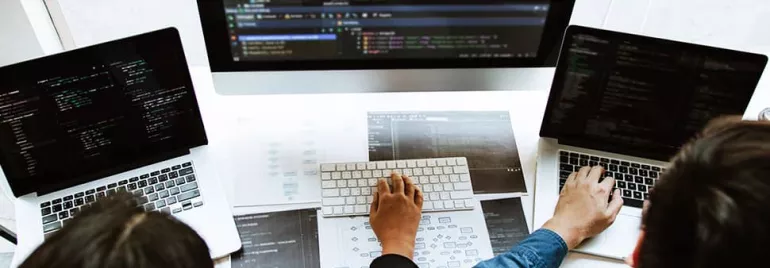 People working on laptops with coding software.