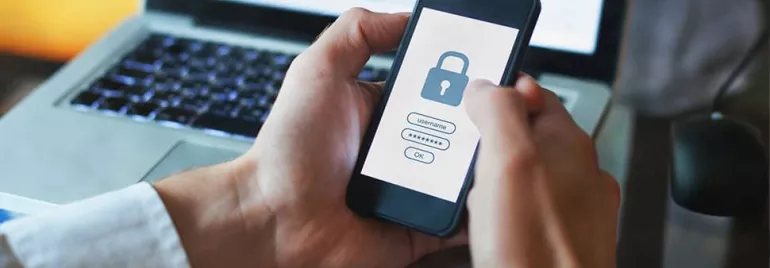 Person holding phone with lock screen login prompt.
