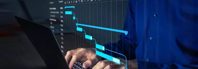 Person typing on a laptop with a Gantt chart displayed on screen.