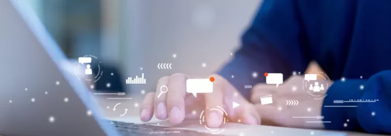 Person typing on laptop with digital icons around.