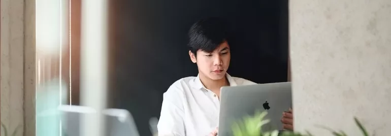 A man sitting at a laptop, discussing career growth opportunities for top talent in a professional setting.