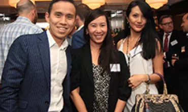 Three people smiling at a social event.