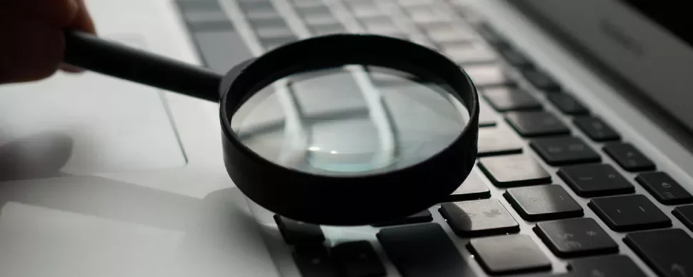 Magnifying glass on a laptop keyboard.
