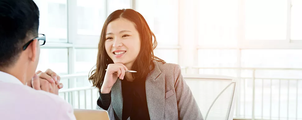 Two people having a conversation in a bright office setting.