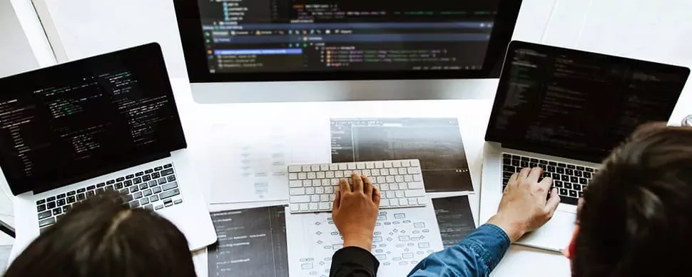 People working on laptops with coding software.