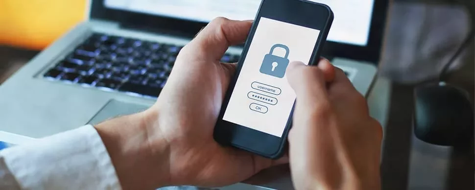 Person holding phone with lock screen login prompt.