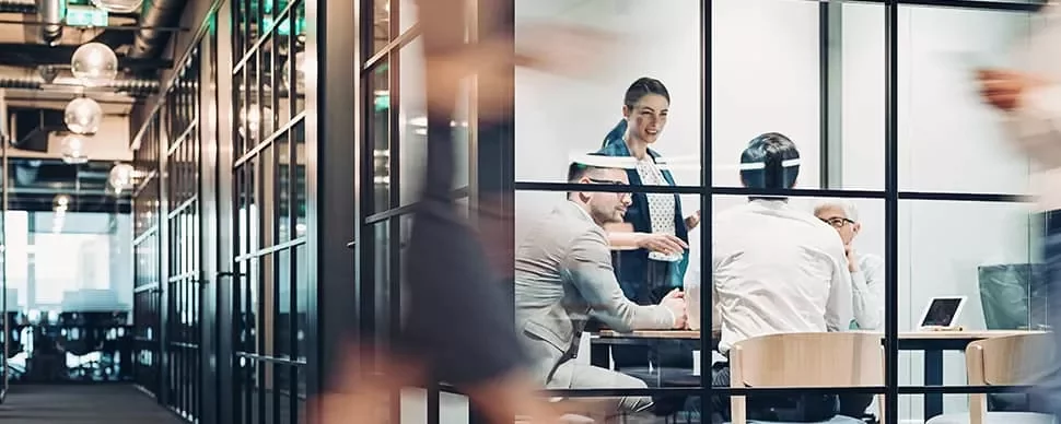 Office team having a meeting in a glass-walled room.