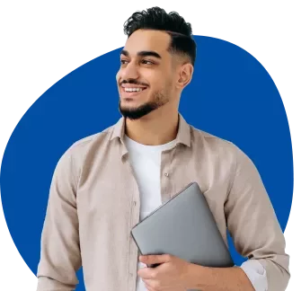 Smiling man holding a laptop against a blue background.