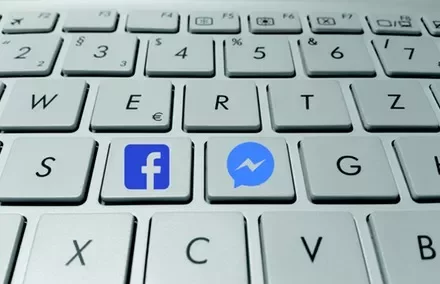 Close-up of a computer keyboard with Facebook and Messenger keys.
