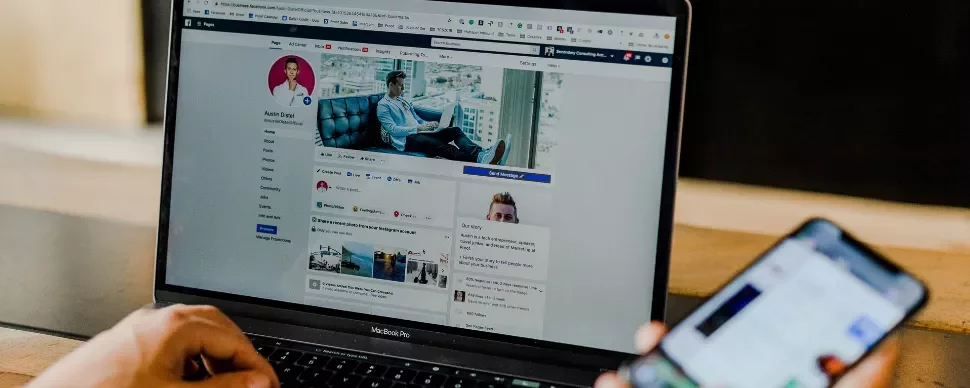 Person using a laptop with a social media profile displayed.